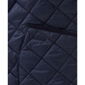 A close-up view of the quilted fabric on the Men's Modern Liddesdale Quilted Jacket in Navy showcases the "Barbour" embroidery. The tailored fit and button tab closure add to its elegant design.