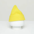 A Le Bonnet yellow woolen Beanie with a pointed top, inspired by traditional Scottish designs, is showcased on a plain white mannequin head against a neutral background.