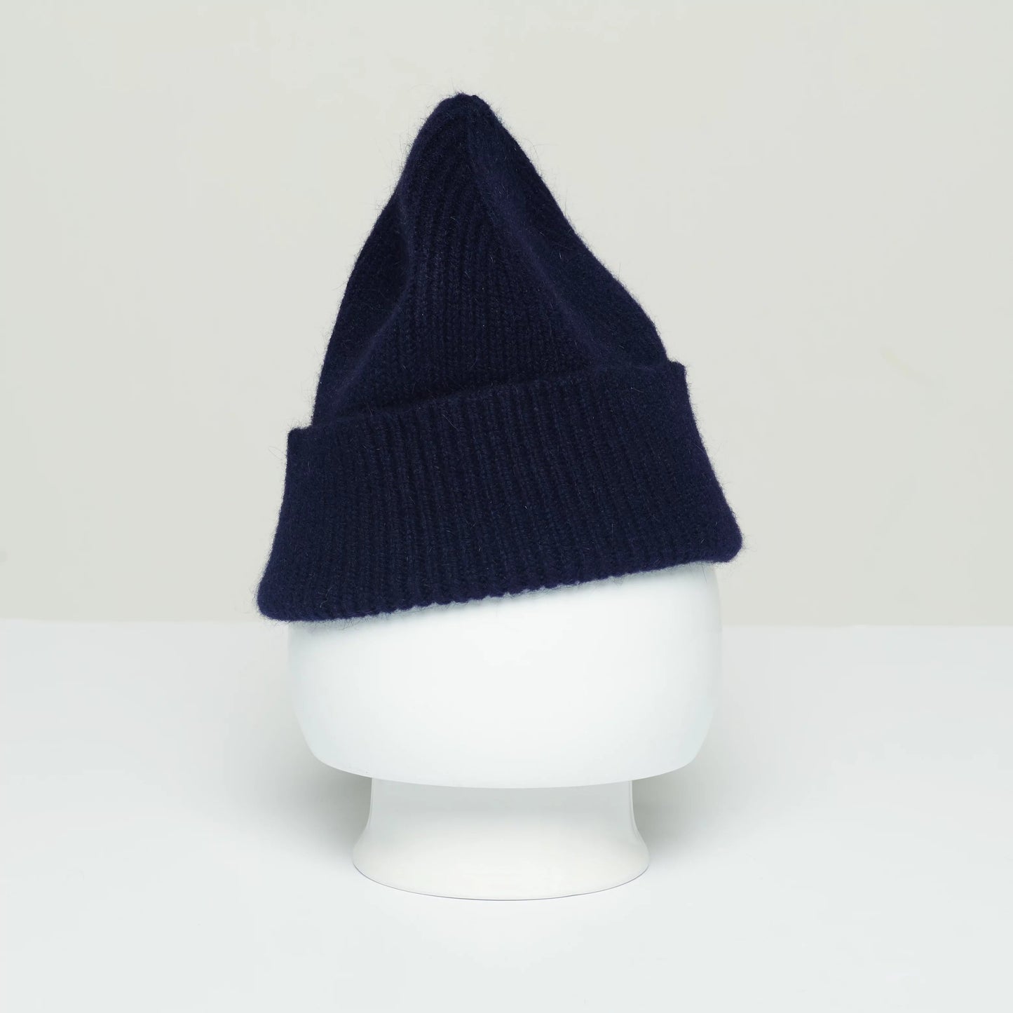 A Beanie by Le Bonnet, crafted from the softest wool in navy blue with a ribbed design, and manufactured in Scotland, is showcased on a white mannequin head against a plain background.