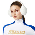 A person wearing cream Fluffy Ear Warmers and a high-collared white and blue top with "Goldbergh" printed in gold text.