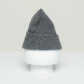 Le Bonnet Beanie with a folded brim, crafted from the softest gray wool, displayed on a white mannequin head against a plain background.