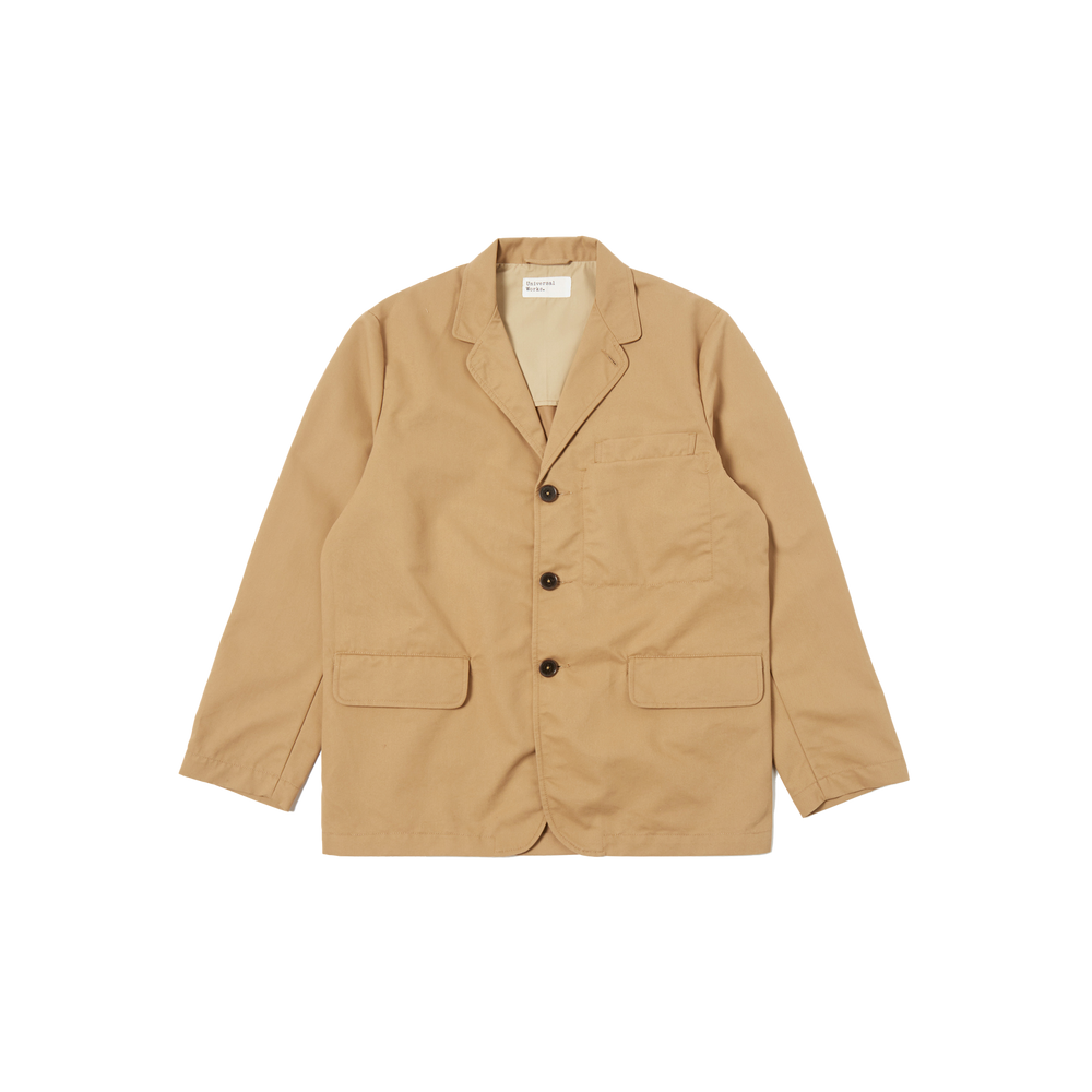 The Capitol Jacket by Universal Works is a tan blazer featuring a notched lapel, three black buttons, and two front pockets, made from recycled polyester. Displayed against a white background.