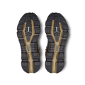 The image displays the expertly crafted shoe soles of the Women's Cloudrock 2 Waterproof by On Running, featuring black and brown hues with textured patterns and brand logos. These soles are specifically designed for speed-hiking boots, offering excellent shock absorption to ensure both durability and comfort on challenging terrains.