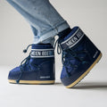 A person pairs stylishly light blue jeans with the Moon Boot Icon Low Nylon in Blue footwear.