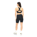 A person facing away from the camera wears a black sports bra and Rohnisch's Flattering High Waist Bike Tights, crafted from recycled polyester, complemented by white socks and sneakers.