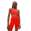 A person wearing Rohnisch’s eye-catching Flattering High Waist Bike Tights, along with a matching bright red sports bra made from breathable fabric, looks directly at the camera.