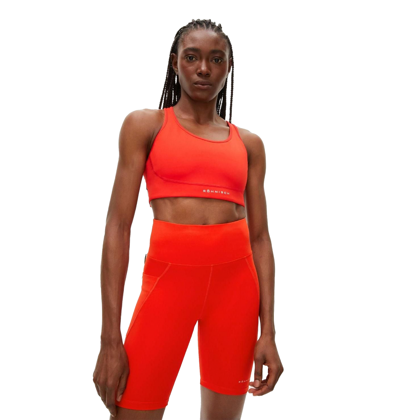 A person wearing Rohnisch’s eye-catching Flattering High Waist Bike Tights, along with a matching bright red sports bra made from breathable fabric, looks directly at the camera.