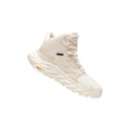 The Hoka W Anacapa MID GTX in Eggnog/Shifting Sand features a single, lightweight leather hiking boot with high ankle support, visible tread for trail traction, and strong laces, set against a white background.