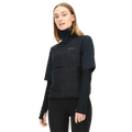 A woman models the Insulate Padded Tee by Rohnisch, featuring a high-collared black vest and long sleeves, against a white background, exuding style and elegance.