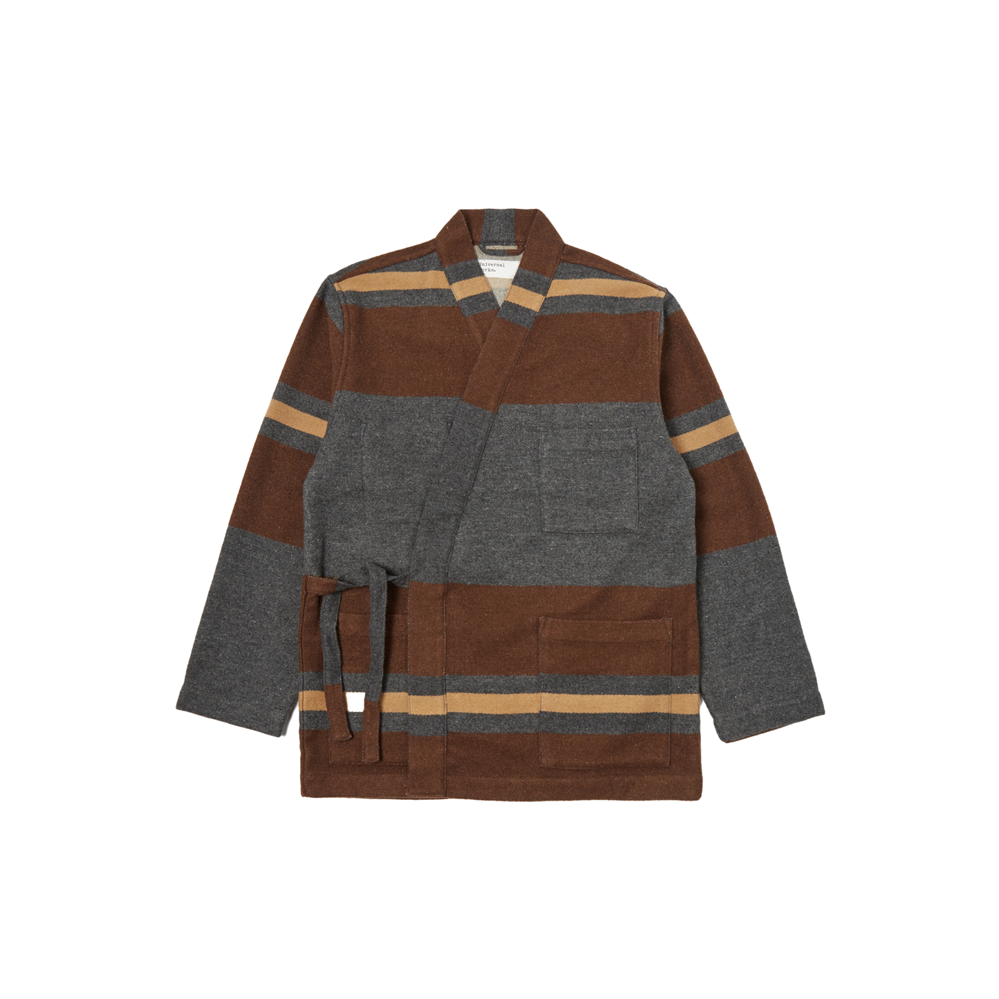 The Kyoto Work Jacket by Universal Works is a heritage-inspired piece, styled like a Japanese kimono jacket, showcasing a brown and gray stripe pattern. It includes a belt, long sleeves, and two front pockets.