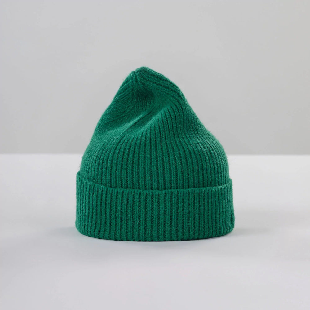 Le Bonnet's Pine Beanie, made of lambswool and featuring a folded brim, is elegantly displayed on a plain white surface.