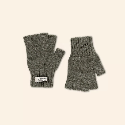 The Fingerless Gloves, Croco by Le Bonnet are gray knit gloves made from Merino wool with ribbed cuffs and the signature label. Displayed elegantly on a neutral background, they are crafted in Scotland to embody life’s small pleasures.