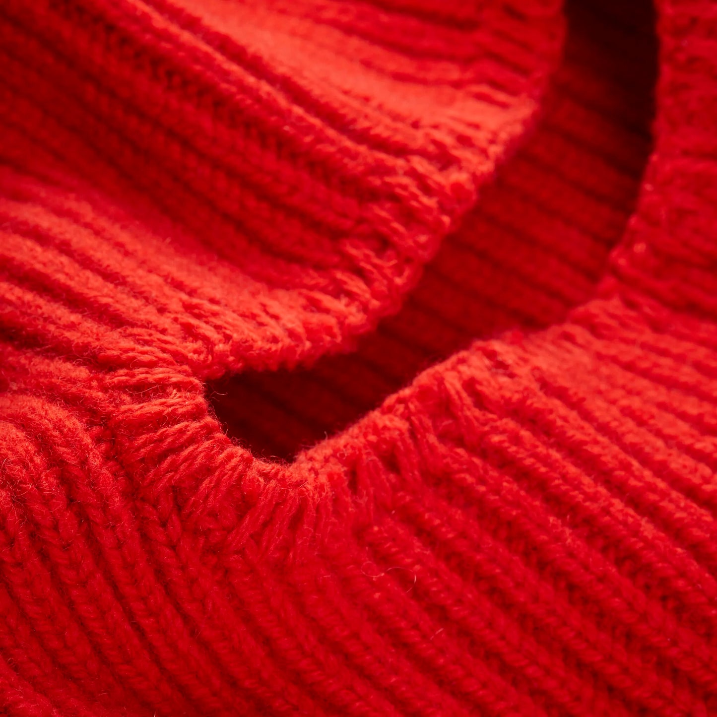 Close-up of a Le Bonnet Balaclava in crimson, featuring a ribbed texture crafted from luxurious cashmere.