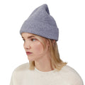 A person with light hair wearing a light gray Le Bonnet lambswool knit beanie and a white sweater, looking to the side.