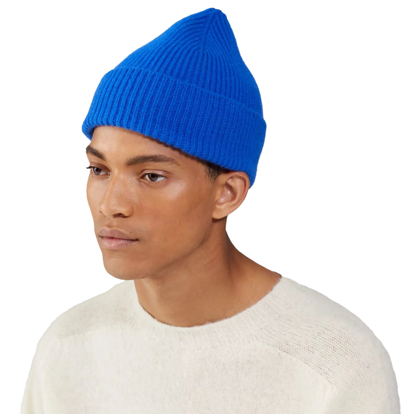 A person wearing a vibrant blue Le Bonnet lambswool Beanie and a cream sweater stands against a plain white background.