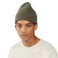 A person wears a beanie by Le Bonnet and a cream sweater against a white background.