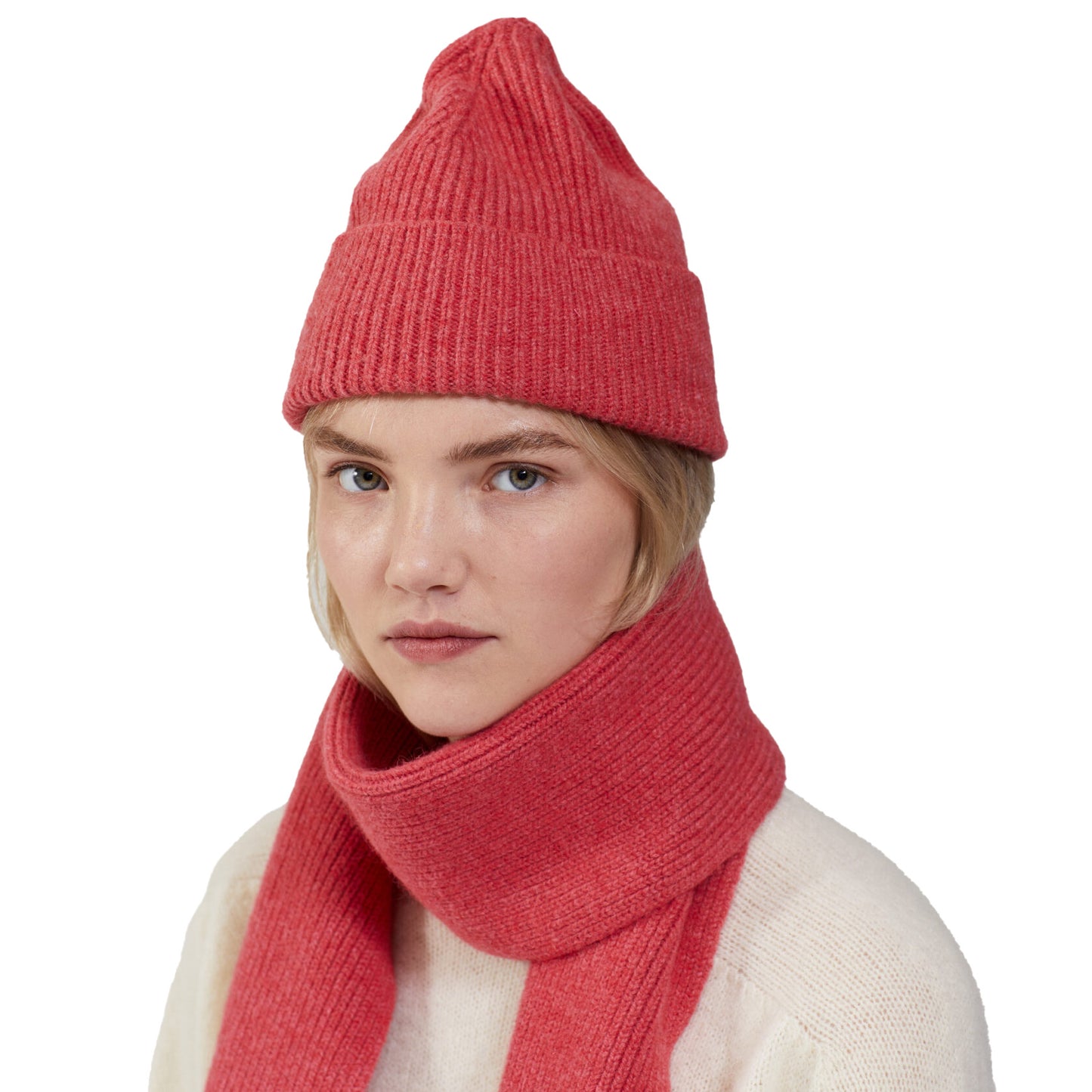 A person wearing a red Le Bonnet lambswool beanie and matching scarf, with a neutral expression, against a white background.