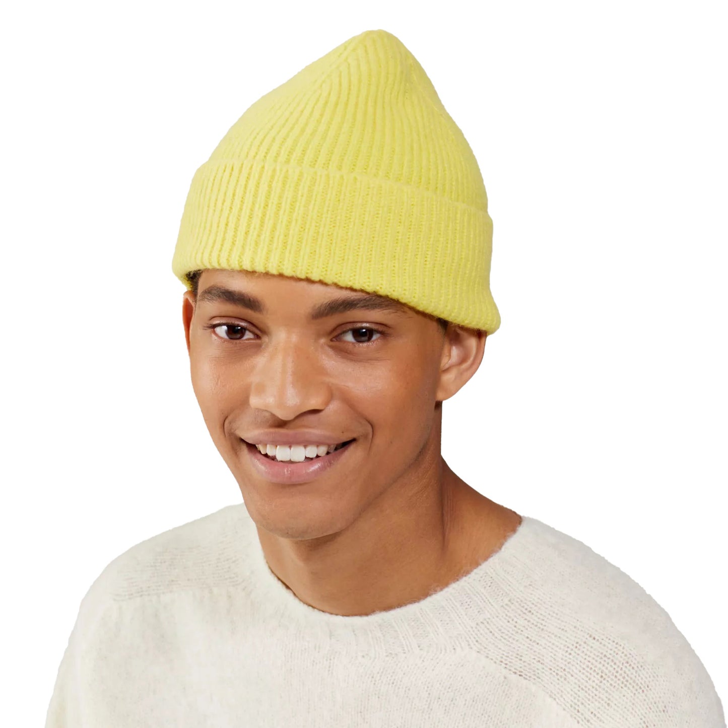 A person wearing a cozy yellow Le Bonnet wool beanie and a light sweater, smiling warmly against a white background.