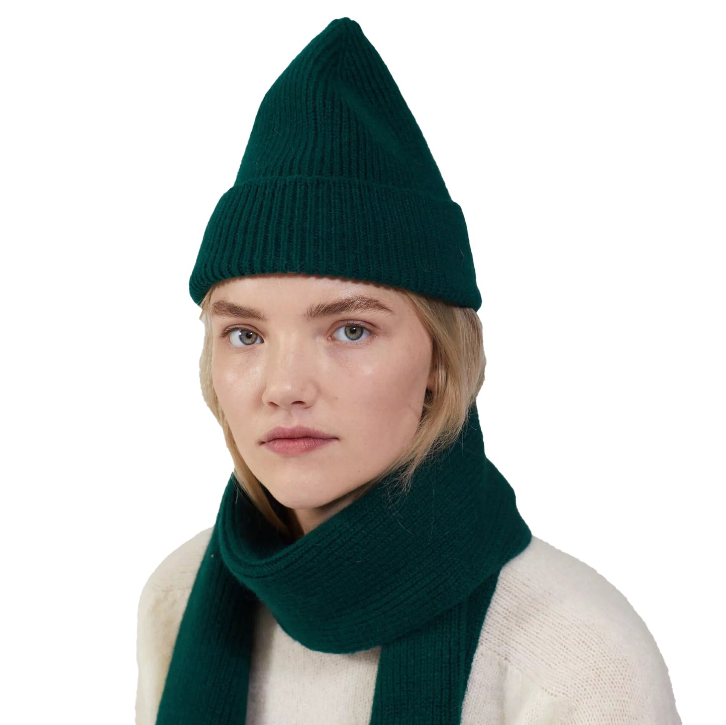 Individual donning a Beanie by Le Bonnet, complemented with a lambswool scarf, displaying a neutral expression against a plain white backdrop.