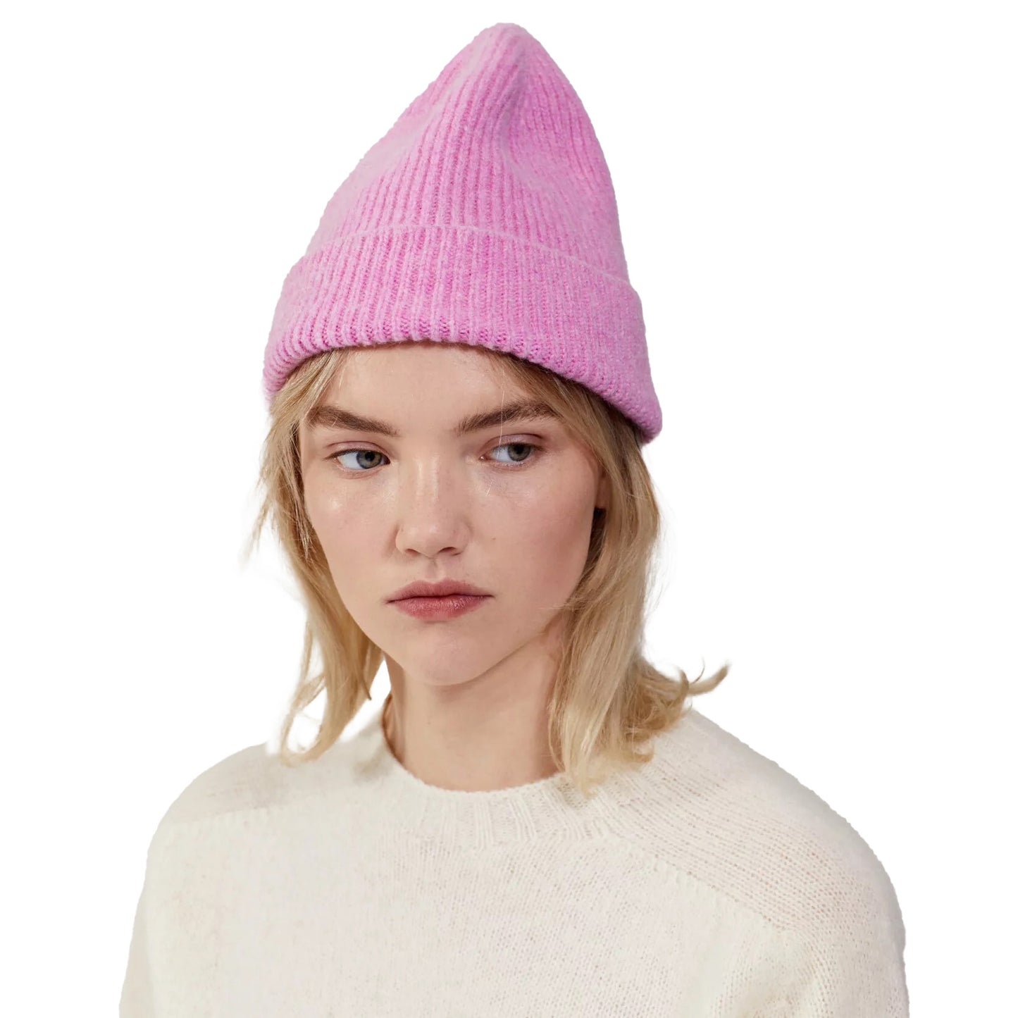 A person wearing a pink Le Bonnet Beanie and a cream sweater, gazing to the side.