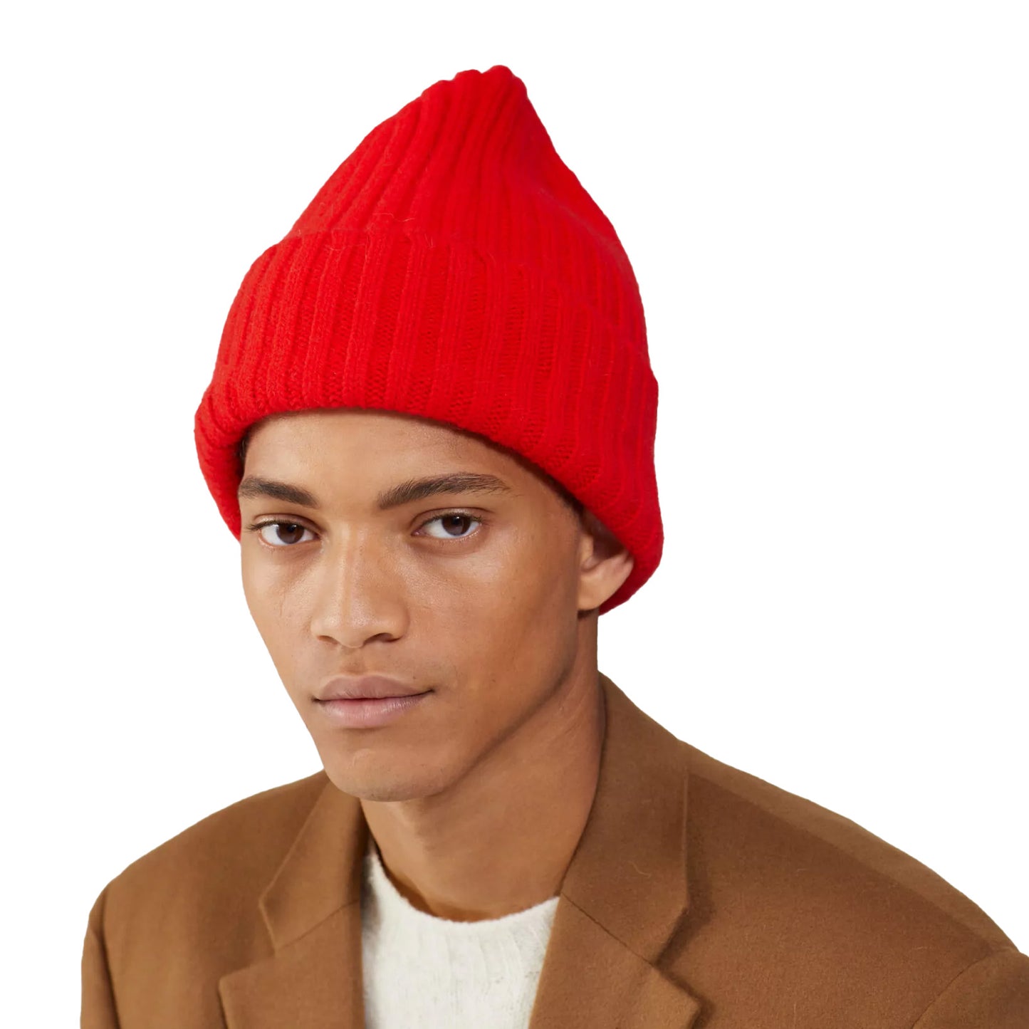 The person is wearing a red Large Beanie by Le Bonnet, a brown coat, and a white shirt against a plain white background.