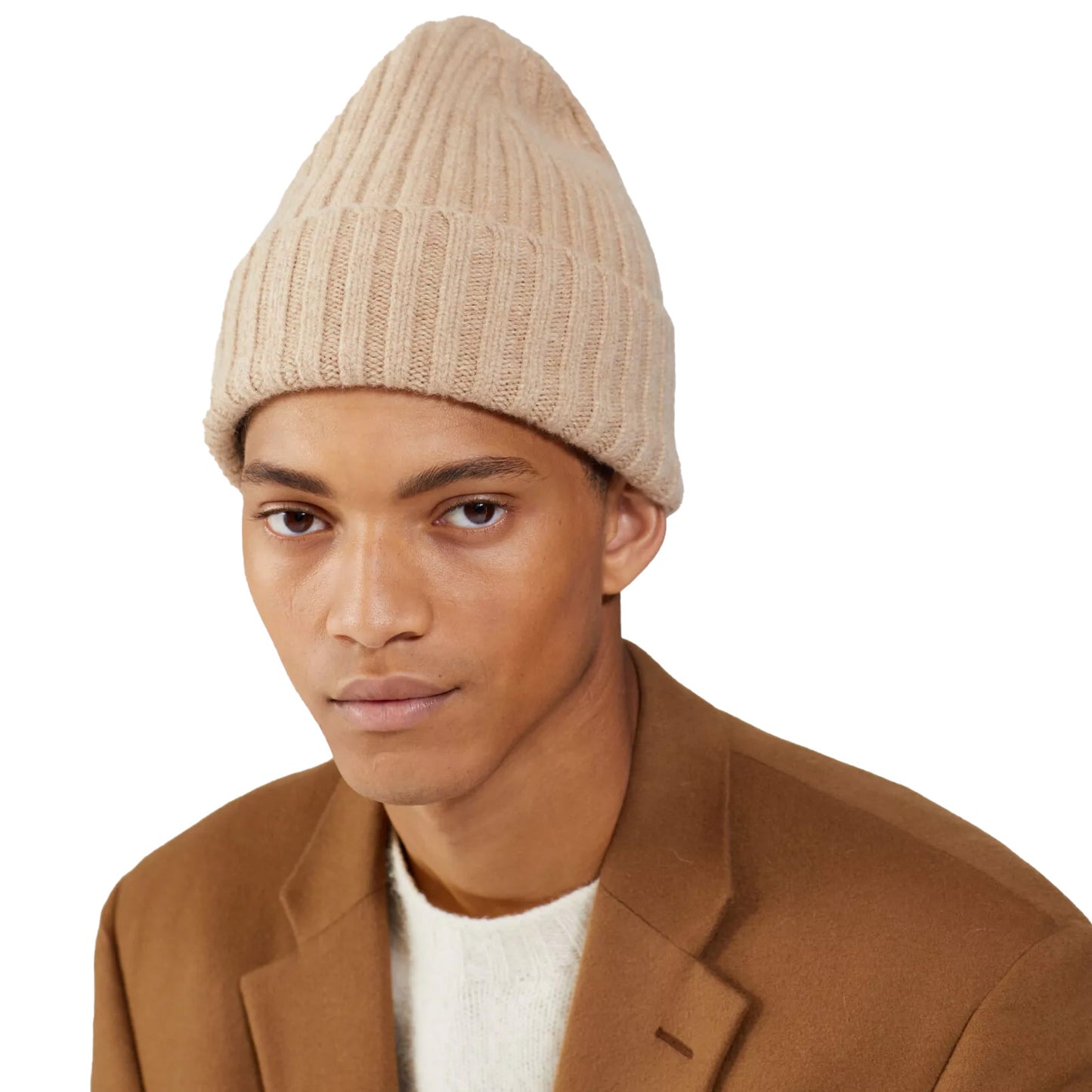 A person wearing a beige Large Beanie by Le Bonnet, a brown blazer, and a white sweater stands against a plain background, exuding extreme comfort.