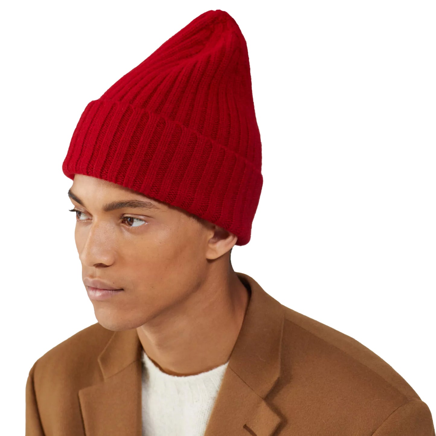 A person wearing a large red beanie by Le Bonnet and a brown coat, facing left against a white background.