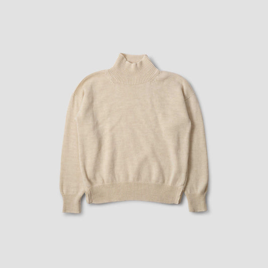 The M's T Shape Roll Neck by Margaret Howell, a beige turtleneck made from merino wool, is displayed on a gray background to highlight its premium quality and warmth.