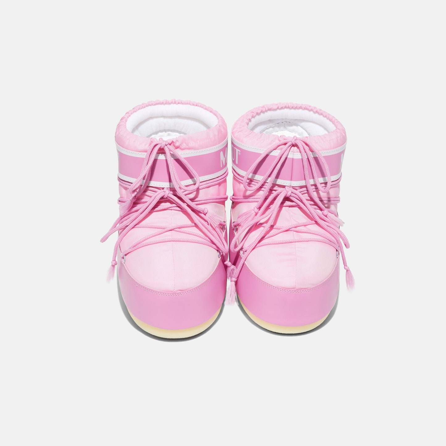 The Moon Boot Icon Low Nylon footwear in pink, featuring white soles and laces reminiscent of astronaut gear, is viewed from above against a plain white background.