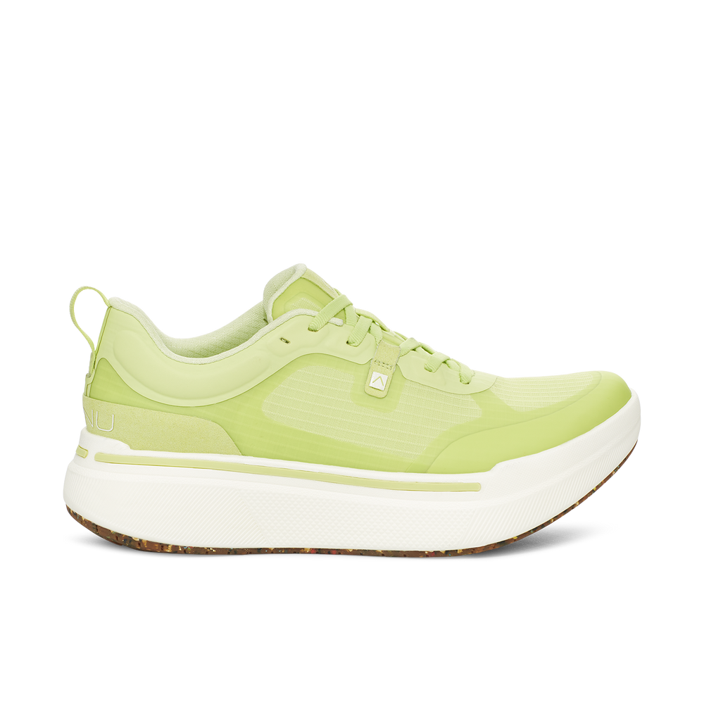 The W Sequence Low, Lime by AHNU is a lime green athletic shoe with a white sole and laces. It features a low-top design, rocker geometry, and a textured finish.