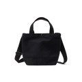 The New York Tote Small by Bags in Progress is a black cotton canvas bag made in Japan, featuring short handles, a detachable shoulder strap, and a button closure at the top.