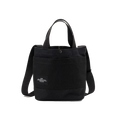 The New York Tote Small by Bags in Progress is a black cotton canvas tote bag featuring dual handles, an adjustable shoulder strap, and a front pocket with a small label on the front.