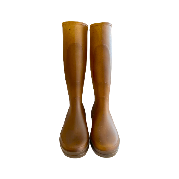 The Kapitana Knee High Boot, Doubure Ecru by Plasticana stands upright, showcasing tall, waterproof brown rain boots crafted from recyclable hemp plastic against a pristine white background.