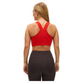 Woman in a red Rohnisch Kay Sports Bra and black leggings, seen from the back, with her hair down.