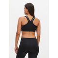 A woman is shown from the back wearing a moisture-wicking black Kay Sports Bra with the brand "Rohnisch" on the straps and matching black leggings made from sustainable recycled polyester.