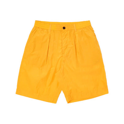 The Pleated Track Shorts by Universal Works in vibrant orange boast an elastic waist and sleek black button closure, perfectly merging comfort with style thanks to a finely pleated front.