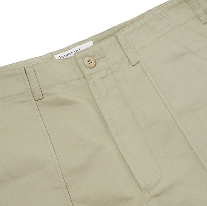 Close-up of Universal Works' Fatigue Pant Twill in Stone, showcasing the button, zipper, and a partially visible label inside the waistband.