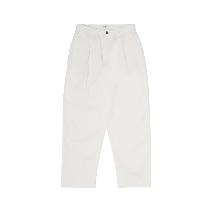 The Oxford Pant in Ecru by Universal Works is a relaxed-fit, high-waisted trouser with a tapered wide leg design, featuring a single pleat and button closure. Displayed elegantly on a white background.