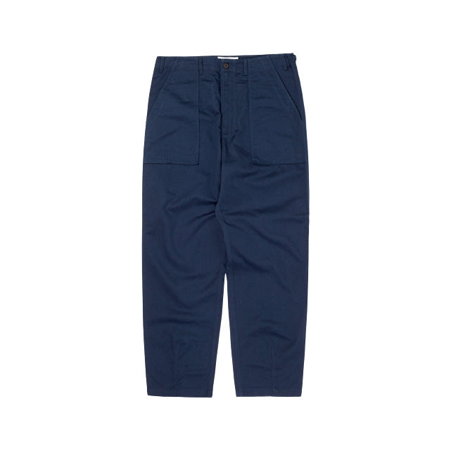 Universal Works' Fatigue Pant Twill in Navy features an oversized military style with large front pockets, button and zip closure, straight legs, and a reinforced waistband. The durable 3/1 twill weave ensures they lay flat on a white background.