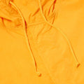 Close-up of the Universal Works BEACH PARKA in orange, showcasing a hood and two drawstrings.