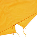 Close-up of an orange fabric with two ties on one edge, likely part of the Universal Works Beach Parka.