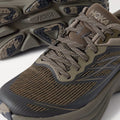 Close-up of the Hoka Stealth/Tech Bondi 8 Caged running shoes in brown and black, featuring textured mesh uppers and patterned soles, displayed on a white background.