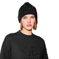 Person wearing the Goldbergh Dream Beanie in black with bead accents and a black sweater featuring a textured logo on the front.