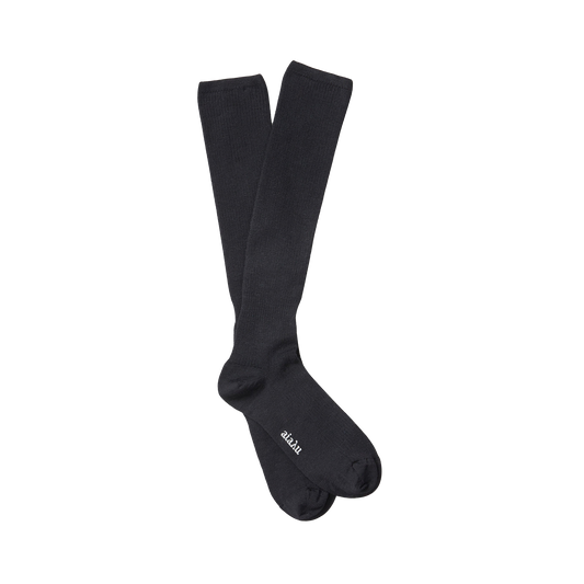 The Aiayu Wool Knee Socks are durable, long black socks made from organic merino wool with the text "futru lan" printed near the toe.