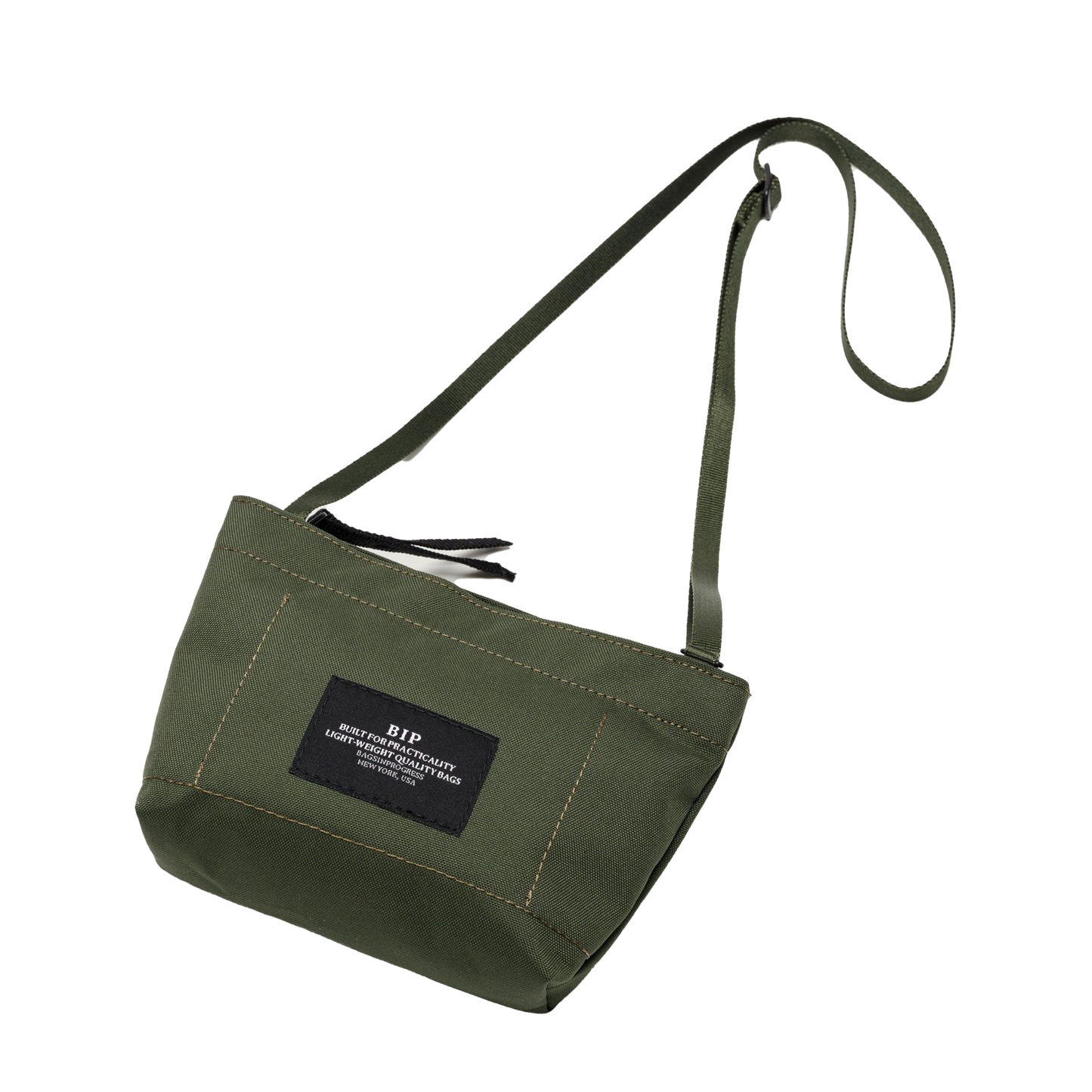 Introducing the Zipper Pouch Mini by Bags in Progress, a green canvas mini shoulder bag made from water-repellent, recycled polyester. It comes with an adjustable strap and features a black rectangular patch on the front.